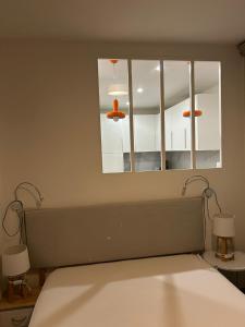 a bedroom with a bed with a mirror and two lamps at Cabourg Face A La Mer in Cabourg