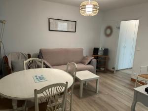 a living room with a table and a couch at Cabourg Face A La Mer in Cabourg