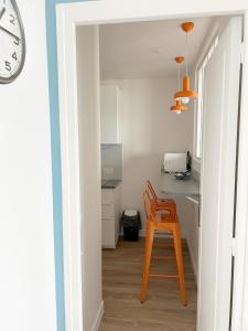 a kitchen with a orange stool in a room at Cabourg Face A La Mer in Cabourg +16 photos
