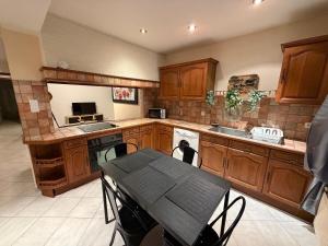 a kitchen with wooden cabinets and a table with chairs at Nid Garona in Carbonne