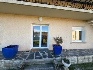 a house with two blue pots in front of a door at Nid Garona in Carbonne