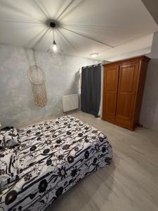 a bedroom with a bed with a black and white comforter at Nid Garona in Carbonne
