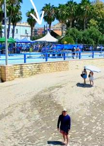 a man walking on the beach with people in the background at Postiguet Beach 2 garajes SuperHost SuperFlat in Alicante +59 photos