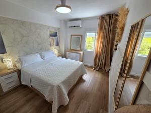 a bedroom with a white bed and a window at Postiguet Beach 2 garajes SuperHost SuperFlat in Alicante
