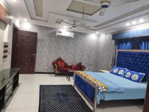 a bedroom with a blue bed and a couch at Elegance Abounds in Qila Malla Singh