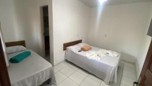 a small room with two beds in it at Pousada e Restaurante Coração De Mãe in Prado