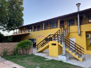 a yellow building with stairs in front of it at Pousada e Restaurante Coração De Mãe in Prado