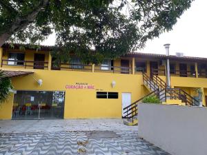 a yellow building with a balcony on top of it at Pousada e Restaurante Coração De Mãe in Prado