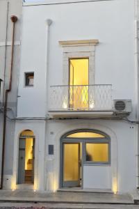a white building with a balcony on top of it at Suite Prima Pietra con Piscina idromassaggio riscaldata in Ostuni