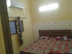 a bedroom with a bed and a light on the wall at Abhinav Home stay in Ayodhya
