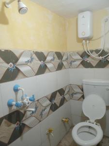 a bathroom with a white toilet in a room at Abhinav Home stay in Ayodhya