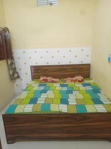 a bed with a colorful quilt on it in a room at Abhinav Home stay in Ayodhya