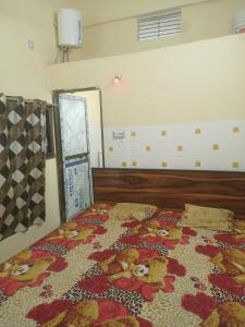 a bedroom with a bed with a floral quilt on it at Abhinav Home stay in Ayodhya