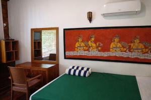 a bedroom with a bed and a painting on the wall at Luck Uyana Cabana Pinnawala in Pinnawala