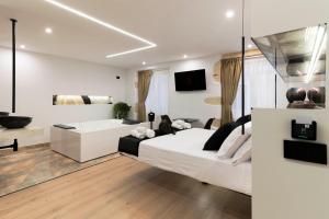 a bedroom with a white bed and a living room at Flá Suite Castello in Cagliari