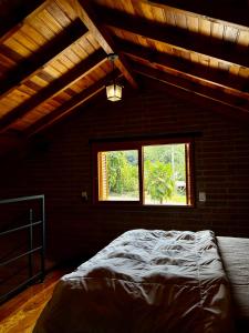 a bedroom with a bed and a window at Villetta Gramado Florença in Gramado