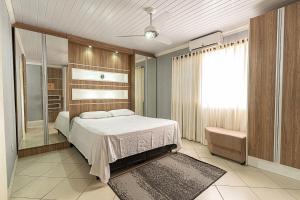 a bedroom with a large bed and a window at Casa Atlântida in Xangri-lá