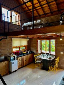 a kitchen with a table and chairs in a room at Villetta Gramado Florença in Gramado