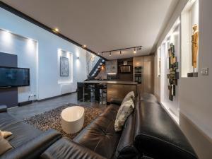 a living room with a leather couch and a kitchen at LE LOFT 67 in Strasbourg