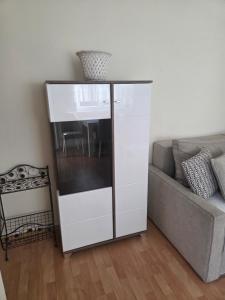 a white entertainment center in a living room next to a couch at Apartman Centar LUX in Jagodina