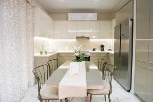 a kitchen with a table and chairs and a refrigerator at Luxury and Cozy Chios in Chios
