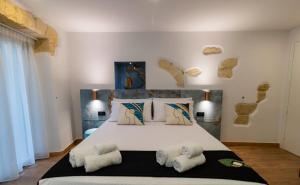 a bedroom with a large bed with towels on it at Flá Suite Castello in Cagliari