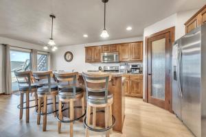 a kitchen with wooden cabinets and a bar with stools at Bridges Bay Vacation Cabin 278 in Arnolds Park