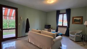 a living room with a white couch and a window at Al Melograno - Villetta - Gussago - Franciacorta in Gussago