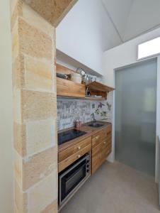eine Küche mit Holzschränken und einer Ziegelwand in der Unterkunft Casa Lorch in Oria + 16 Fotos