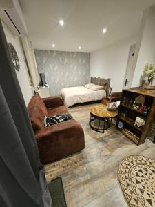 a living room with a couch and a bed at Studio tout confort in Blaye-les-Mines