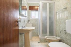 a bathroom with a toilet and a sink and a shower at Private Room in Corroios 15 Minutes from the Beach - Quarto Privado em Corroios com Fácil Acesso à Praia e Lisboa in Corroios