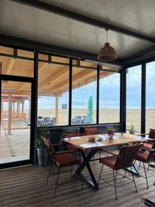 a dining room with a table and chairs and the beach at Mango Beach and Hotel in Fier