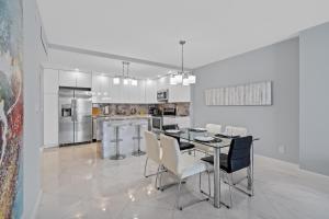a white kitchen with a table and chairs in it at MIAMI Collins Beach Apartments in Sunny Isles Beach