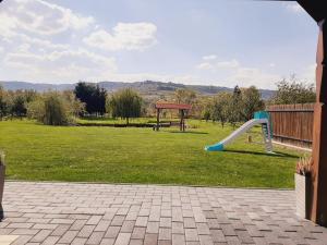 a playground with a slide in the grass at Kacsó Apartma in Ocna de Sus