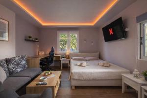 a bedroom with a bed and a couch and a desk at Hot Tub - 5 min to Beaches - Private Garden - Netflix in Lampi