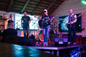 a group of three men playing instruments on a stage at LE TOI DU MONDE in Flumet