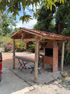 a picnic shelter with a picnic table and a brick oven at Pousada Mandacaru, próximo a Usina de Arte in Campestre