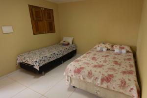 a bedroom with two beds and a window at Pousada Mandacaru, próximo a Usina de Arte in Campestre