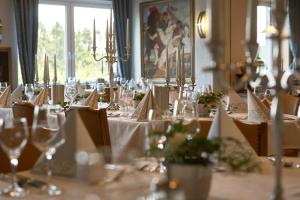 a dining room with tables with white table cloth and glasses at Hotel Zur Burg Sternberg in Extertal +120 photos