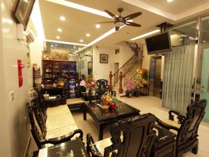 a living room with a table and chairs and a ceiling fan at Nanwan Jiahewu Inn in Nanwan
