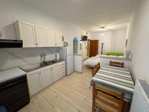 a kitchen with a table and a room with a bed at Bettys rooms in Paralio Astros
