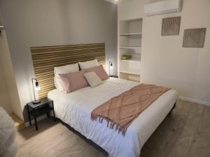a bedroom with a large white bed with pink pillows at Domaine de Zely in Fontaines-dʼOzillac +36 photos