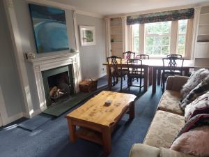 a living room with a couch and a table and a fireplace at Hawks Nest in Selkirk