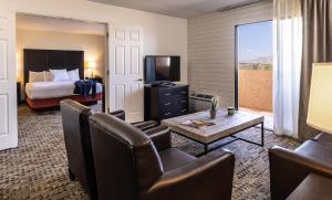 a hotel room with a king bed and a living room at Lake Powell Resort in Page