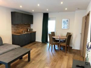 a living room with a table and chairs and a kitchen at City Apartments, Outlet 100 Meter in Metzingen