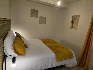 a bedroom with a white bed with yellow pillows at Domaine de Zely in Fontaines-dʼOzillac