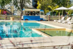 an ice cream truck parked next to a swimming pool at Colors Holiday Hotel in Siófok +37 photos