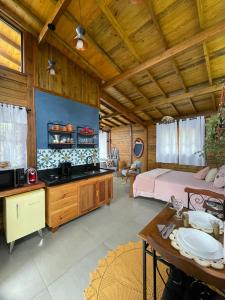 a large room with a bedroom and a bed and a table at Chalé Alecrim in Córrego do Bom Jesus