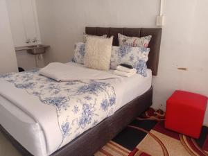 a bed with blue and white sheets and pillows at Happy Guest House in Mahikeng +12 photos