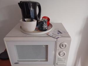 a microwave with a cup on top of it at La maison de J et B étage entier in Tarbes